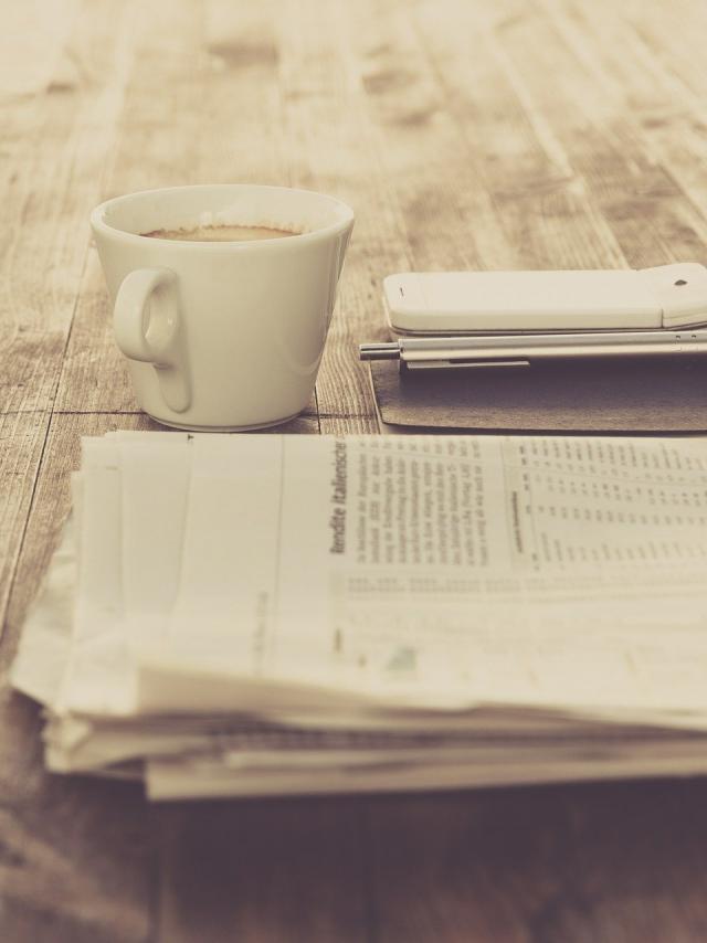 Journal et tasse à café sur une table